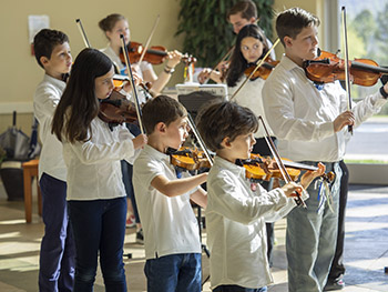 Eight kids playing violin