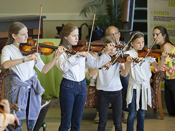 Four kids playing violins