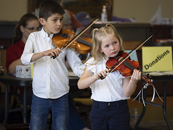 2 children playing violin