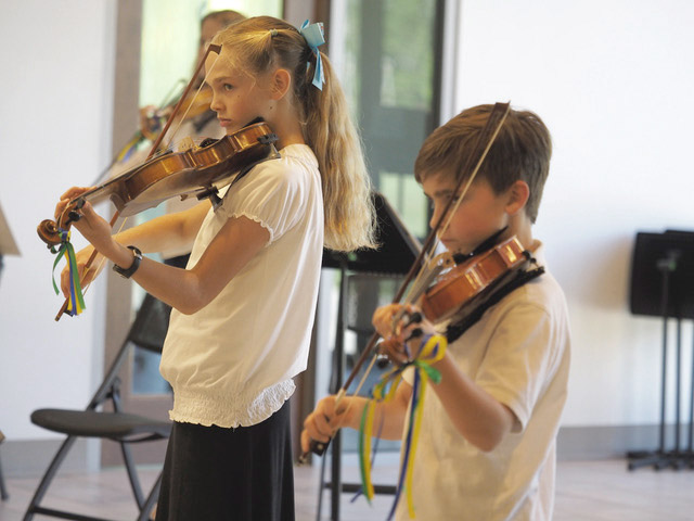 2 children playing violin